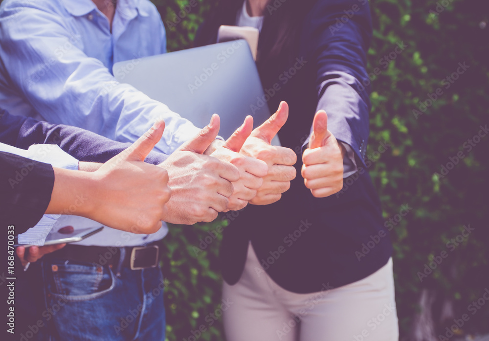 Close up at Group of businessman and woman thumbs up in front of office,success concept,dramatic filter tone Close up at Group of businessman and woman thumbs up in front of office,success concept,dramatic filter tone