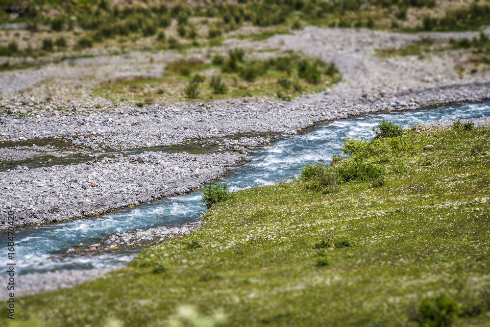 Fototapeta premium A small blue river flows in the mountainous country of Georgia.