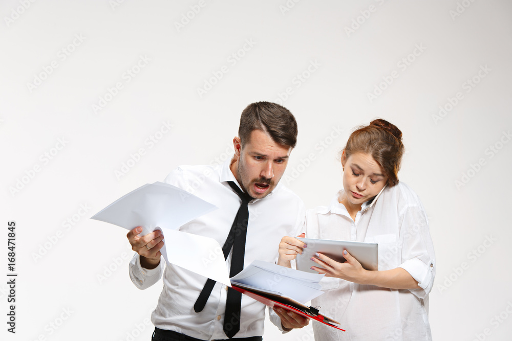 The business man and woman communicating on a gray background The business man and woman communicating on a gray background