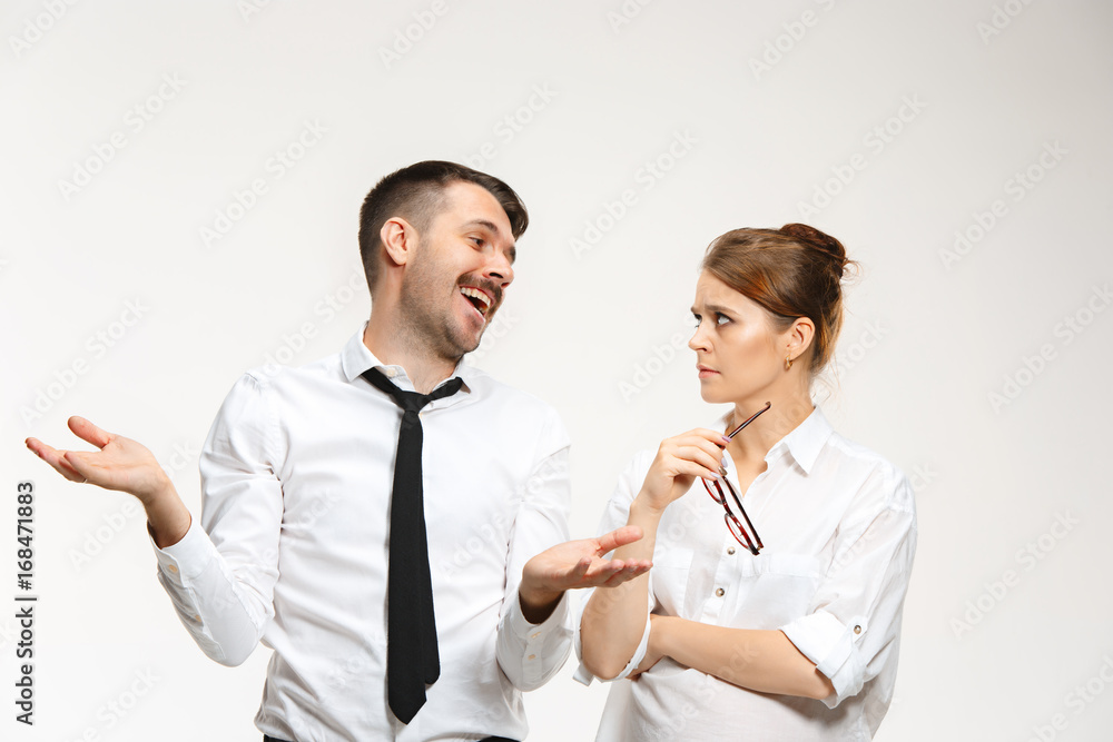 The business man and woman communicating on a gray background The business man and woman communicating on a gray background