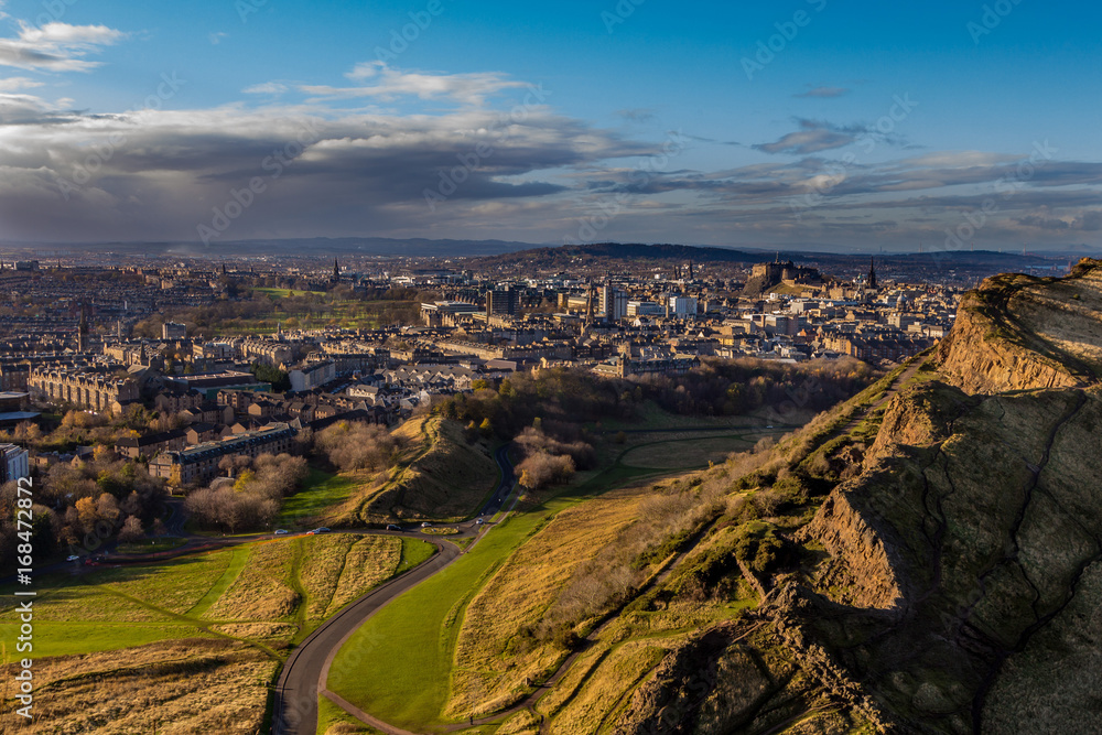 view across Edinburgh from Salisbury crags with rain clouds in the distance