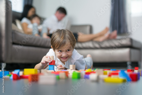 Caucasian boy play wooded toy in living room in home with his father and mother, children, kid, boy, mom,dad and family concept