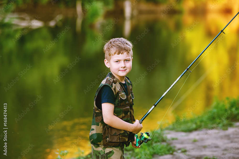Boy catches fish in the river.The concept of tourism and leisure Boy catches fish in the river.The concept of tourism and leisure