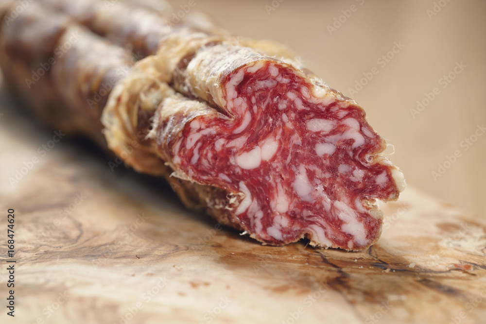 part of dried italian salami on table part of dried italian salami on table