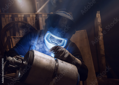 Welding of stainless steel pipes with argon, welding mask close-up