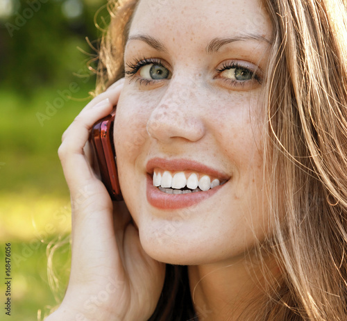 Closeup portrait of young woman talk on mobile telephone