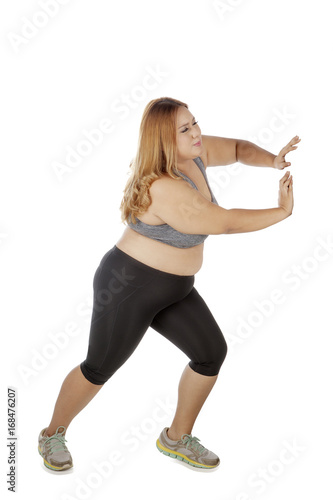 Overweight woman pushing something