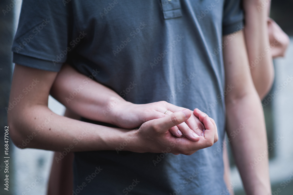 Hands are woven. A woman's hand lies in the man's hand. A guy and a girl are holding hands.