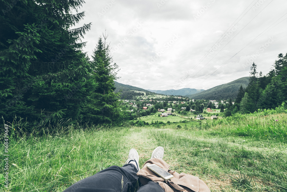 Fototapeta premium man lying on the ground and enjoying view of mountains
