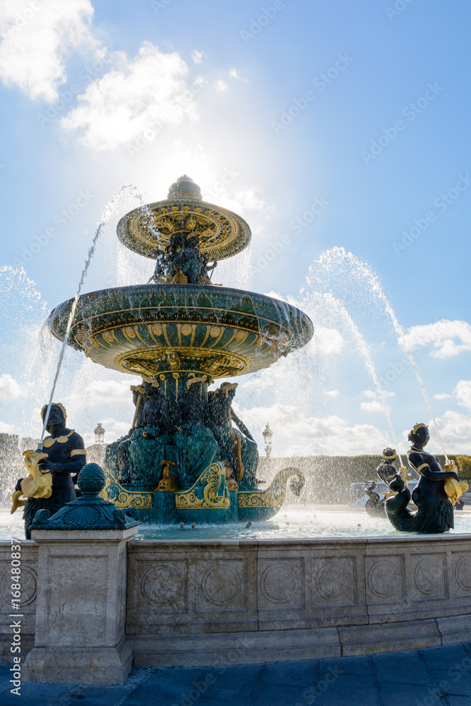 The Fountain of the Rivers, on the Concorde square in Paris, France, with statues of Nereids and Tritons holding golden fishes spitting water to the upper basin.