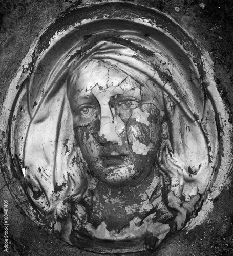 Virgin Mary statue. Fragment of vintage ancient sculpture. (Religion, faith, suffering, love concept)