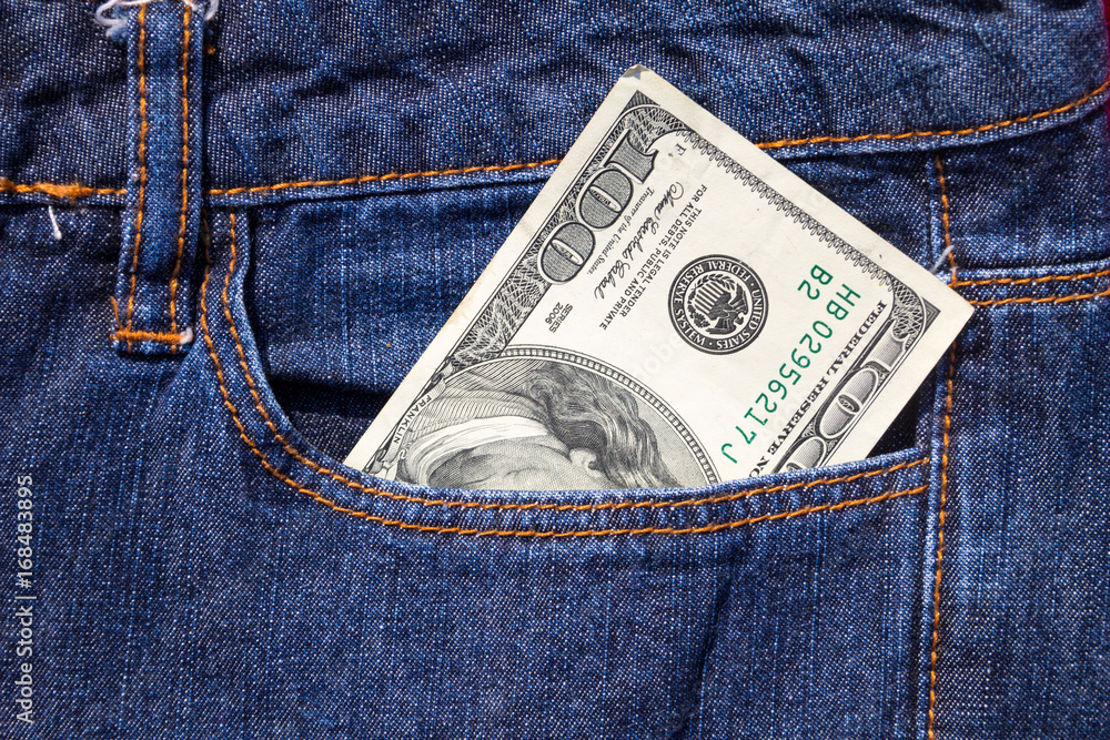 One hundred American dollars bill in the pocket of blue jeans One hundred American dollars bill in the pocket of blue jeans