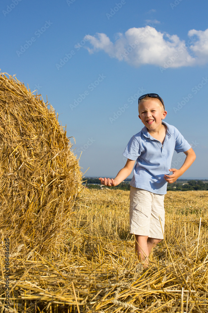 The boy is playing a straw field The boy is playing a straw field