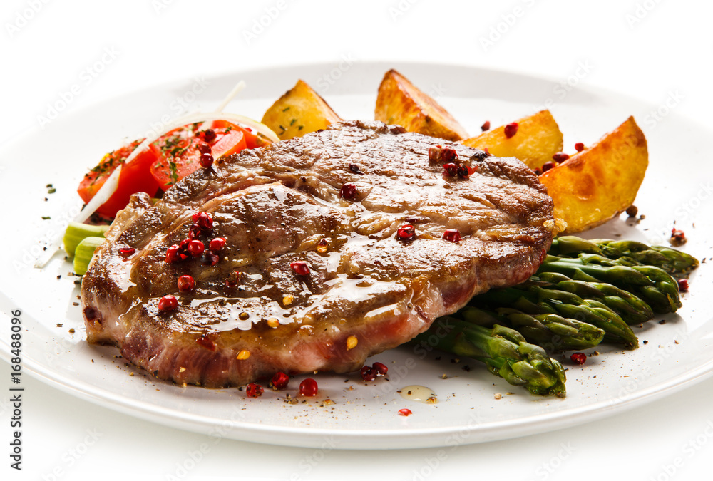 Grilled beef steaks,chips and asparagus on white background