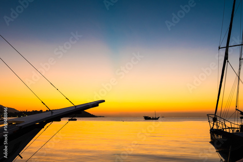 Fototapeta Naklejka Na Ścianę i Meble -  Beautiful golden sunset and blue sky over sea with boat in summer.