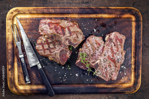 Two Barbecue dry aged Wagyu Porterhouse Steaks as close-up on a cutting board