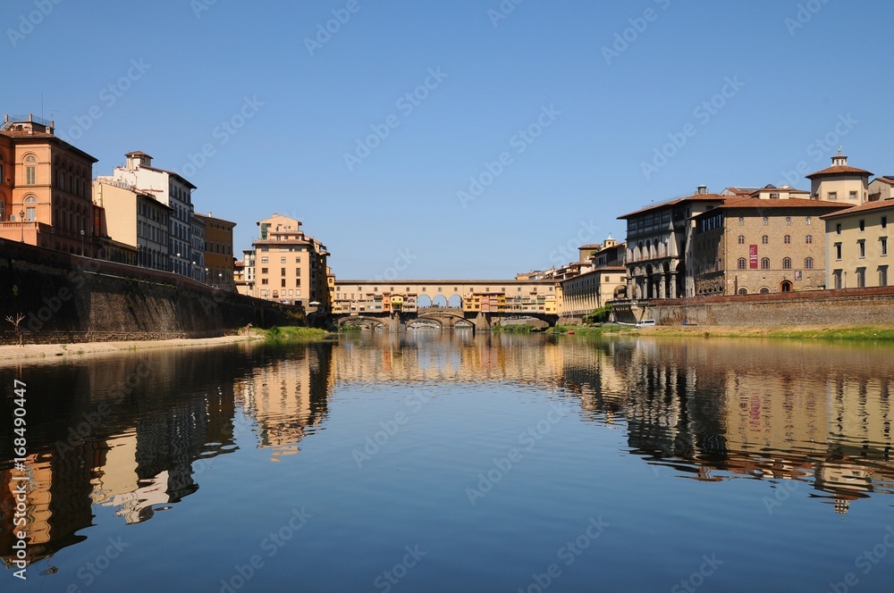Panoramic view of famous Old Bridge (Ponte Vecchio) with blue sky in Florence, Italy.