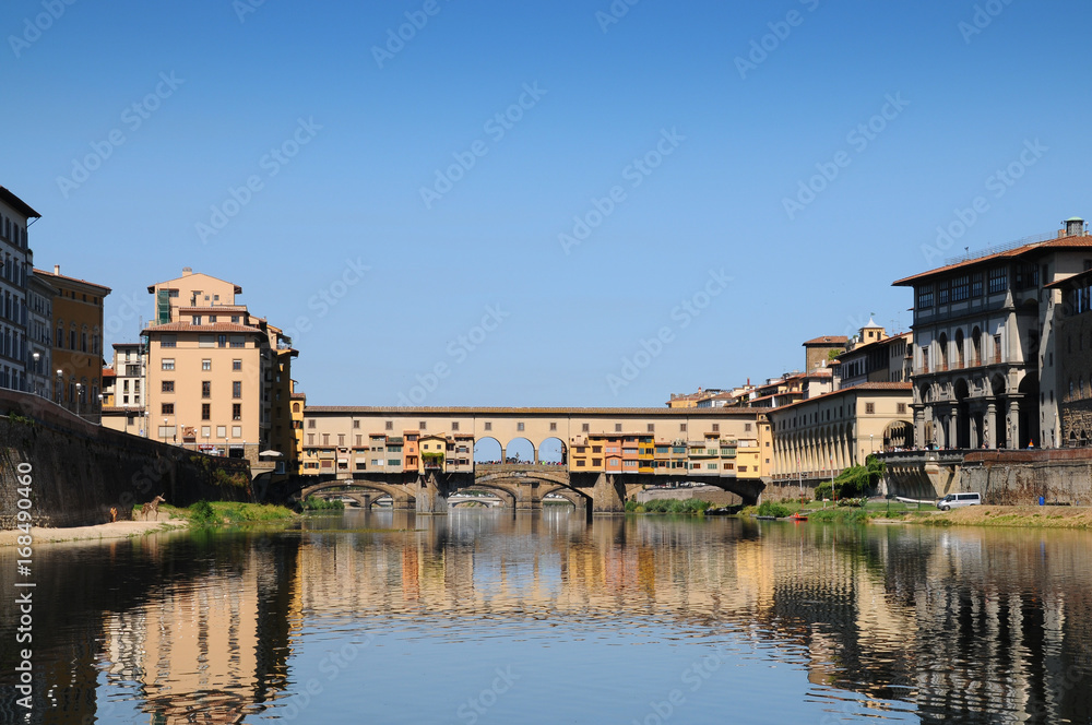 Panoramic view of famous Old Bridge (Ponte Vecchio) with blue sky in Florence, Italy.