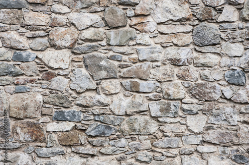 Gray weathered rocky brick wall. Decorative rough blocks pattern.