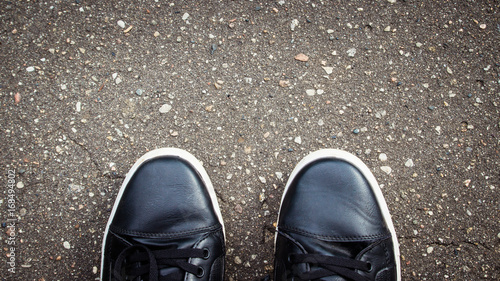 Black road asphalt texture pattern background. Shoes.