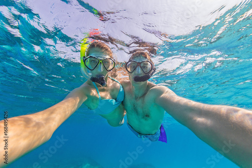 Young couple enjoying snorkeling underwater. Selfie portrait