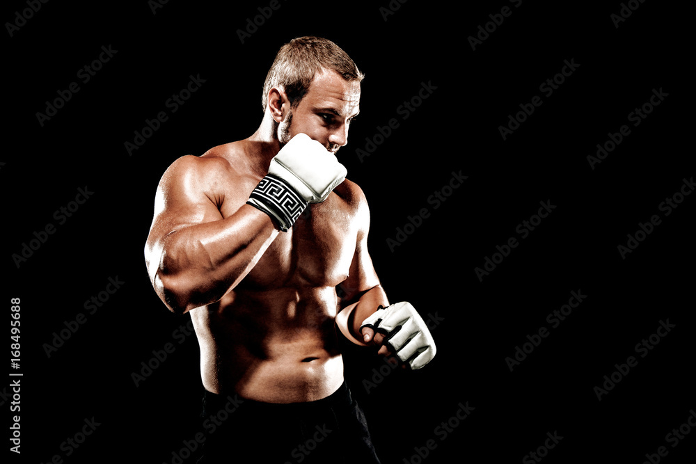 Sportsman muay thai boxer fighting in boxing cage. Isolated on black background. Box trainer on ring hitting