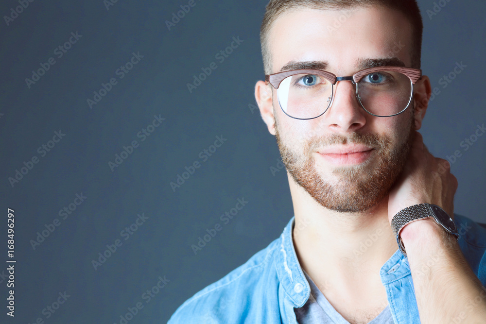 Portrait of a happy casual man standing isolated on a dark background