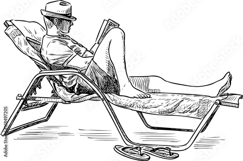 A man reads a book on the seashore
