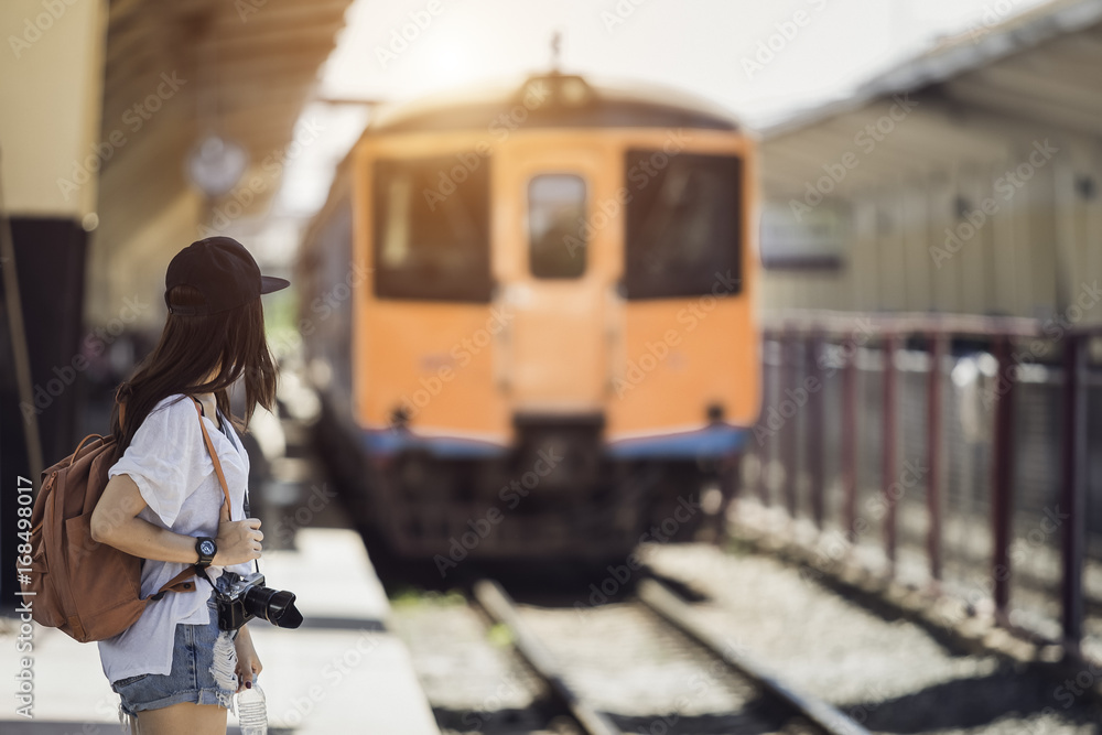 Obraz premium Traveler woman walking and waits train on railway platform