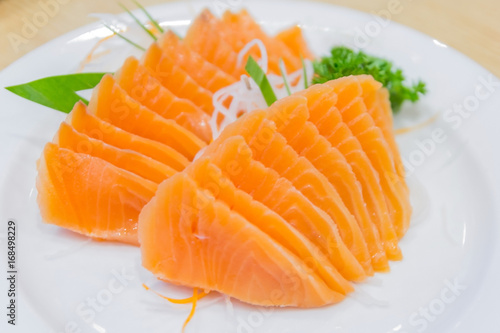 Salmon sashimi served with preserved ginger in white plate on wood table, Japanese food style