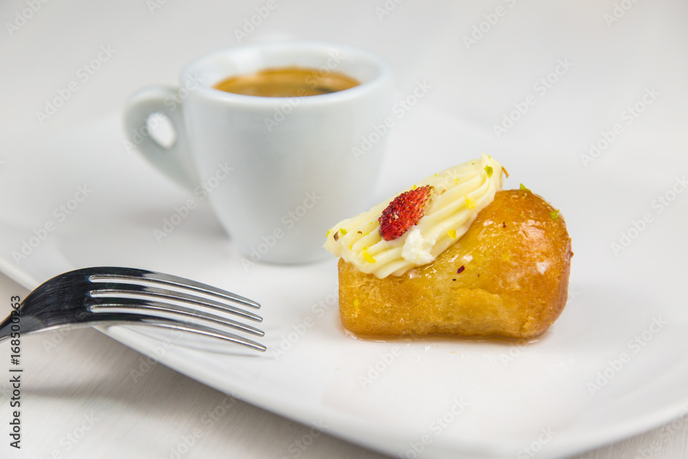 Neapolitan babà and coffee on white white dish