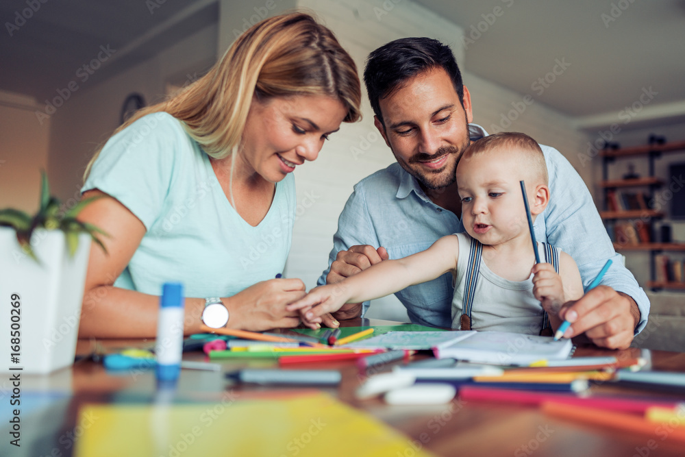 Smiling family drawing together at home Smiling family drawing together at home