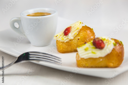 Neapolitan babà and coffee on white white dish