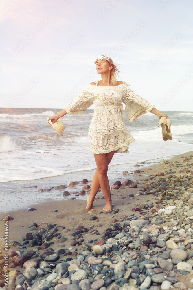 woman in white dress walking barefoot on the beach woman in white dress walking barefoot on the beach