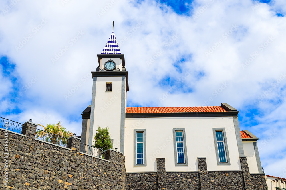 Church building against blue sky with white clouds on coast of Madeira island, Portugal