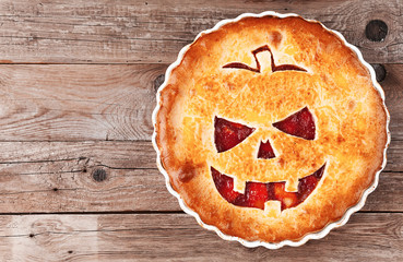 Delicious homemade pie for halloween with a filling of pumpkin-strawberry jam and peaches