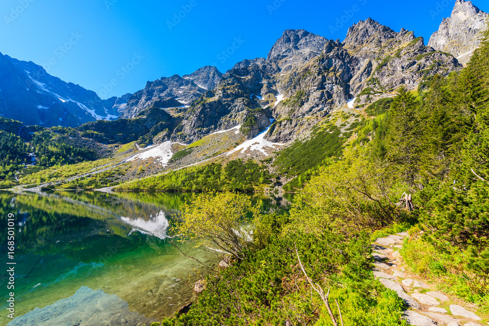 View of Morskie Oko lake with emerald green water in summer season, High Tatra Mountains, Poland
