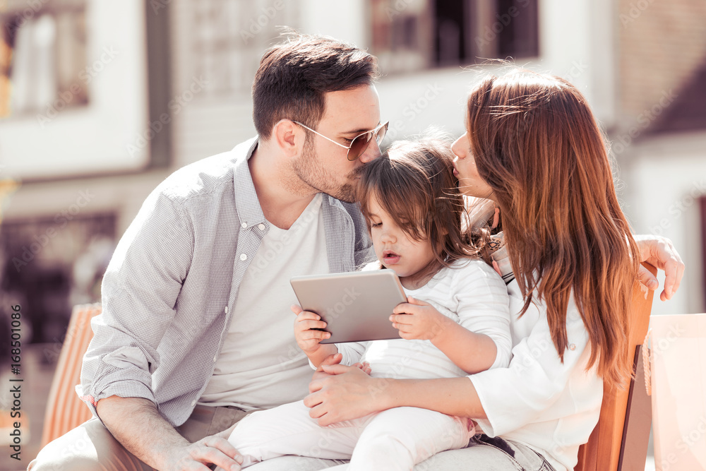 Happy family in the city looking at tablet. Happy family in the city looking at tablet.