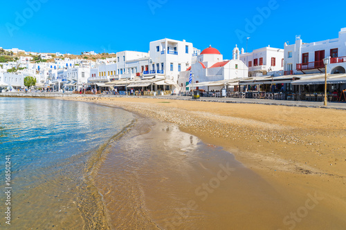 MYKONOS PORT, GREECE - MAY 16, 2016: View of beautiful beach and restaurants on shore in Mykonos town, Mykonos island, Greece.