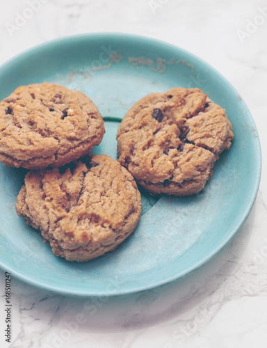 Closeup of crunchy chocolate chip cookies or biscuits on a decorative plate on marble background