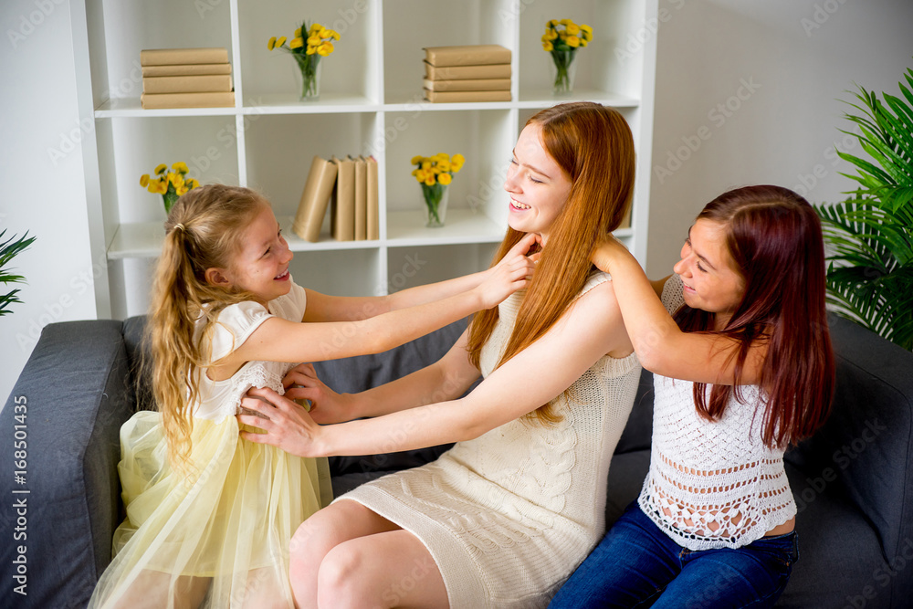 Fototapeta premium Mother and two daughters playing and tickling