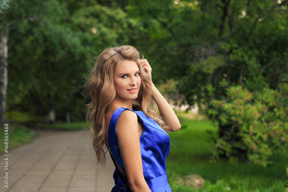 Beautiful girl is walking in a blue dress