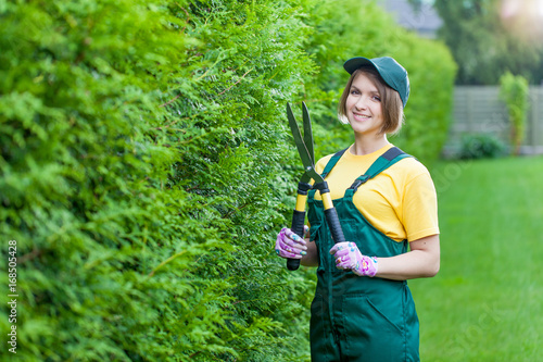 Young smiling woman florist working in the garden.