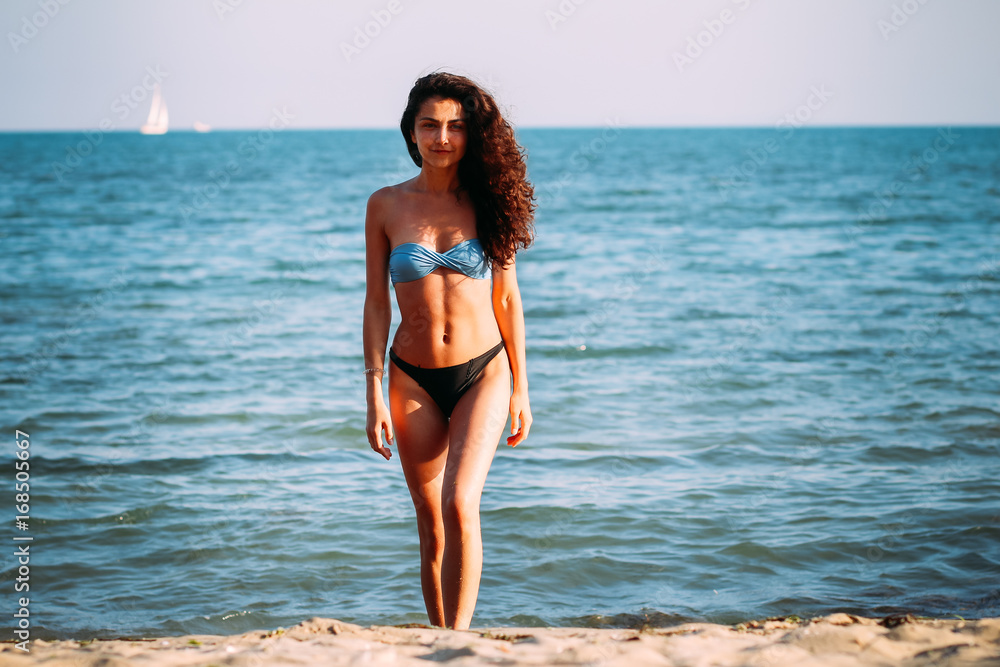 Hight fashion colors,Glamour Portrait of pretty beautiful fashion woman in bikini posing in summer near the sea and blue sky in sunshine,tropic island girl on vacation