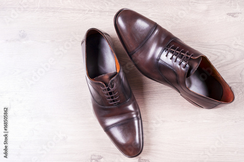 Male fashion with shoes on wooden background.
