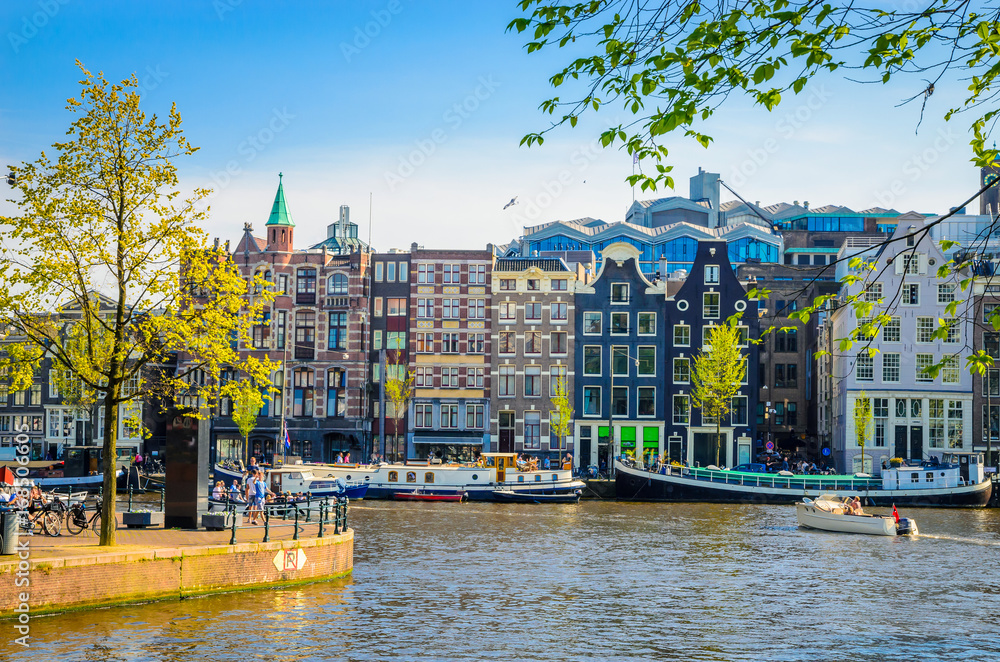 Traditional old buildings and and boats in Amsterdam, Netherlands. Canals of Amsterdam.