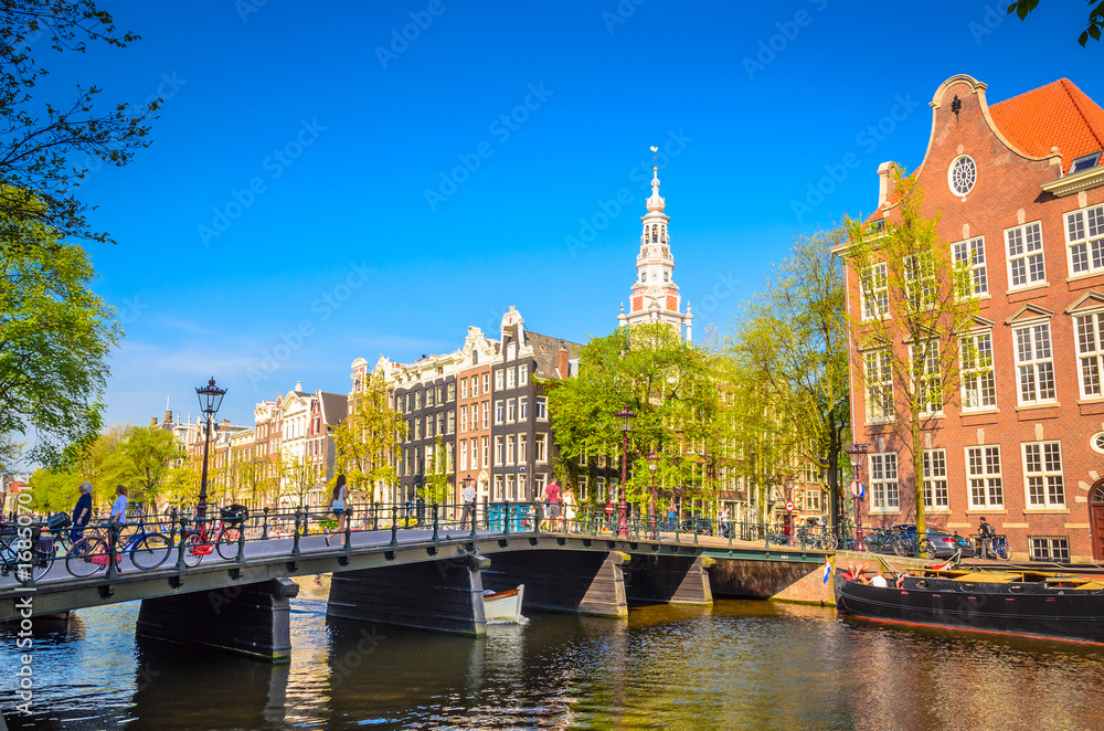 Obraz premium Traditional old buildings and and boats in Amsterdam, Netherlands. Canals of Amsterdam.
