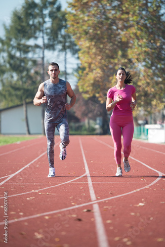 Athletic Couple Sprinting on the Running Track