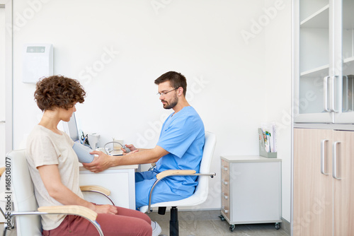 Doctor Measuring Blood Pressure on Patient
