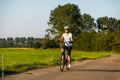 Woman riding bicycle in countryside